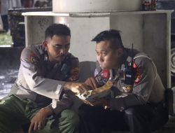 Dua Polisi Nikmati Nasi Bungkus Bersama di Dermaga Bakauheni Saat Hujan Deras